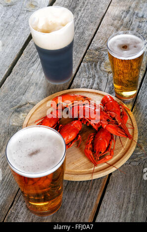 Tasty boiled crayfishes and beer on old table Stock Photo