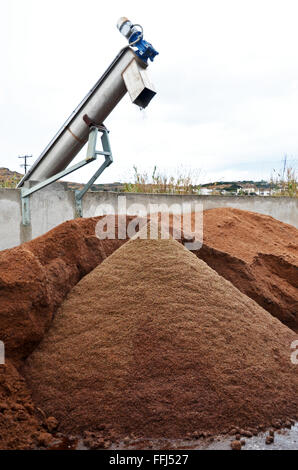 Olive press cake, or olive mill pomace, a byproduct of olive oil production, piles up outside an olive press, Syros, Greece Stock Photo