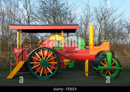 A brightly painted antique steamroller provides a colourful climbing frame in a children’s playground. Dorchester, Dorset, England, United Kingdom. Stock Photo