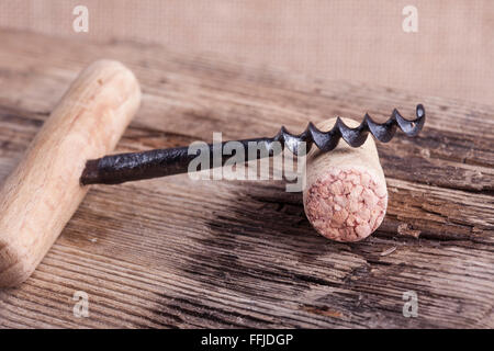 old corkscrew and wine cork on wooden surface macro closeup Stock Photo