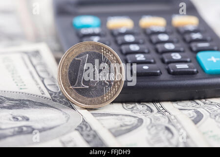 coin one euro closeup, calculator on the banknotes of dollars Stock Photo