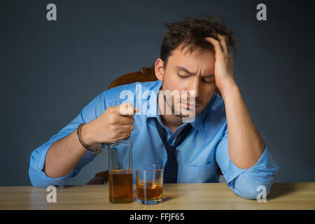 Drunk man drinking alcohol at the table Stock Photo