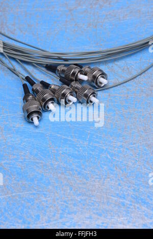 Fiber optic cable pigtails on blue background Stock Photo