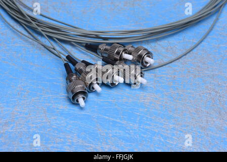 Fiber optic cable pigtails on blue background Stock Photo
