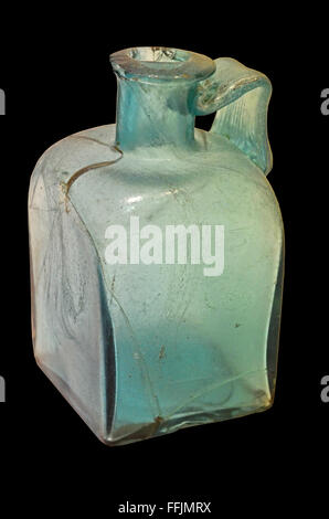 2nd century ancient roman light blue green bottle with handle and square base. Isolated against a black background Stock Photo