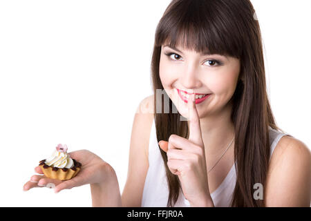 Portrait of young beautiful smiling woman holding in her palm delicious tart cake with cream and chocolate in dough basket Stock Photo