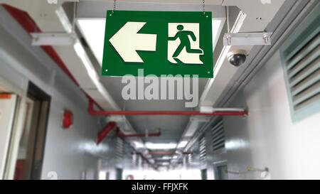 Emergency exit sign in hallway of apartment Stock Photo