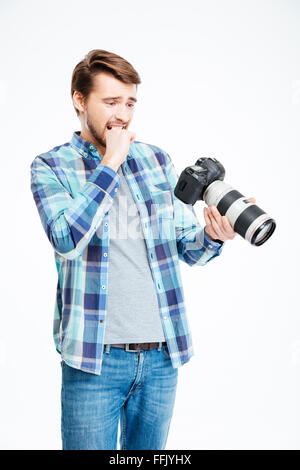 Stressed male photographer holding photo camera isolated on a white background Stock Photo