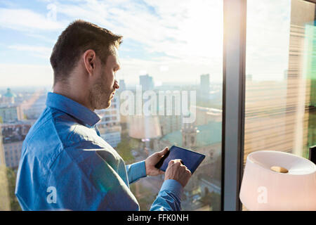 Businessman in apartment using digital tablet Stock Photo