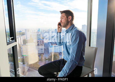 Businessman in apartment on the phone Stock Photo