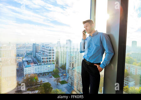 Businessman in apartment on the phone Stock Photo