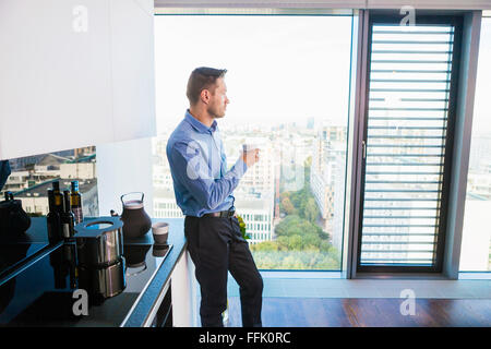 Businessman in apartment having a coffee break Stock Photo