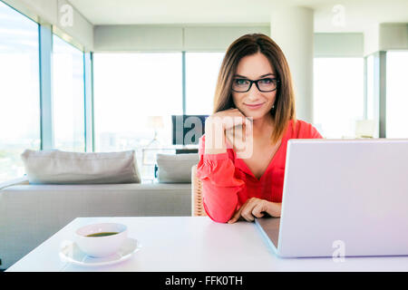 Woman in apartment using laptop computer Stock Photo