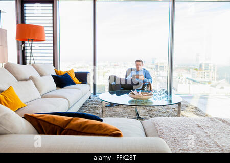 Businessman in apartment using digital tablet Stock Photo