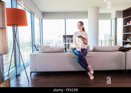 Woman in apartment using digital tablet Stock Photo