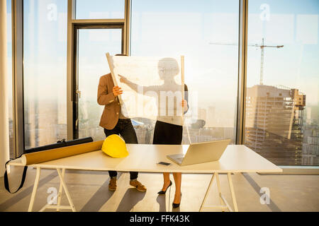 Two architects in office examining blueprint Stock Photo
