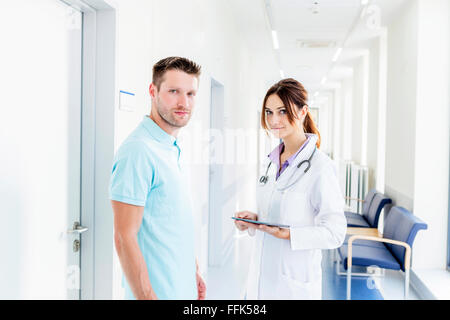 Female doctor and coworker standing in hospital corridor Stock Photo