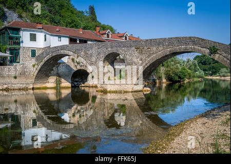 Rijeka Crnojevica old bridge panoraic view with reflections on the calm river waters. Stock Photo