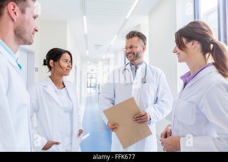 Doctor and coworkers talking in hospital corridor Stock Photo