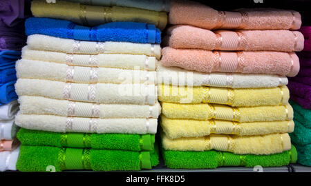 Stacks of multi colored towels on shelf Stock Photo