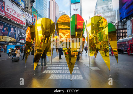 Visitors view their reflections in 'Heart of Hearts', the winner of the Times Square Valentine Heart Design in Times Square in New York on Tuesday, February 9, 2016. The sculpture by Collective-LOK creates a golden kaleidoscopic space that mirrors the cacophony and visual stimulation that attracts so many visitors to Times Square. The sculpture will be on view until March 6. (© Richard B. Levine) Stock Photo