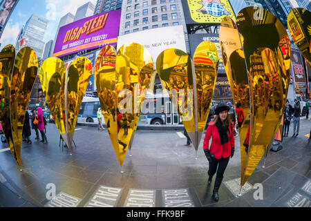 Visitors view their reflections in 'Heart of Hearts', the winner of the Times Square Valentine Heart Design in Times Square in New York on Tuesday, February 9, 2016. The sculpture by Collective-LOK creates a golden kaleidoscopic space that mirrors the cacophony and visual stimulation that attracts so many visitors to Times Square. The sculpture will be on view until March 6. (© Richard B. Levine) Stock Photo