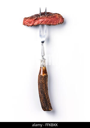 Sliced beef steak ribeye on meat fork on white background Stock Photo