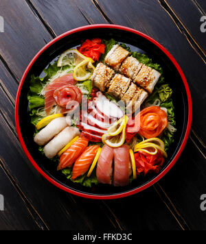 Sushi Set nigiri, rolls and sashimi served in traditional Japan black Sushioke round plate Stock Photo