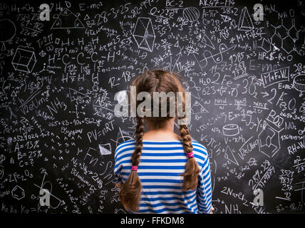 Girl  against big blackboard with formulas, back view Stock Photo