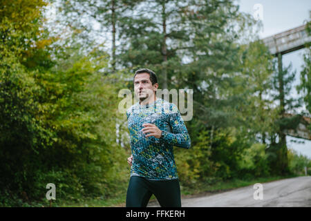 Man running on an old road in green nature. Stock Photo