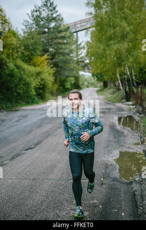 Man running on an old road in green nature. Stock Photo