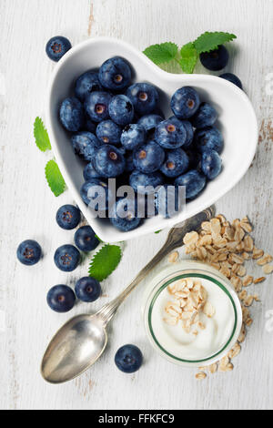 Healthy breakfast of muesli, berries with yogurt and seeds on white background -  Healthy food, Diet, Detox, Clean Eating or Veg Stock Photo