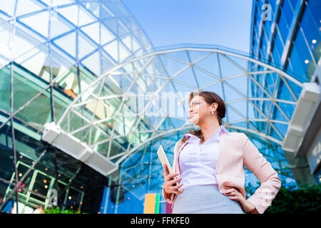 Businesswoman holding a tablet against glassy modern office buil Stock Photo