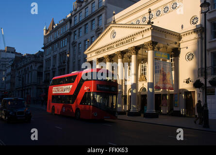 Red London bus passing the sunlit exterior of the Haymarket Theatre in central London. The Theatre Royal, Haymarket (also known as Haymarket Theatre or the Little Theatre) is a West End theatre in the Haymarket in the City of Westminster which dates back to 1720, making it the third-oldest London playhouse still in use. Stock Photo