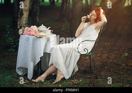 Beautiful redhead woman in white shirt on the light green