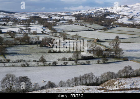 Snow dusted farmland in Upper Teesdale in County Durham, England. Dry stone walls divide the fields. Stock Photo