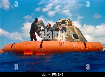 NASA Apollo 14 astronaut Edgar D. Mitchell, lunar module pilot, is assisted out of the Command Module by a U.S. Navy underwater demolition team swimmer during the Apollo 14 recovery operations February 9, 1971 in the South Pacific Ocean. Mitchell was followed out of the spacecraft by astronauts Alan B. Shepard Jr., commander; and Stuart A. Roosa, command module pilot. Stock Photo