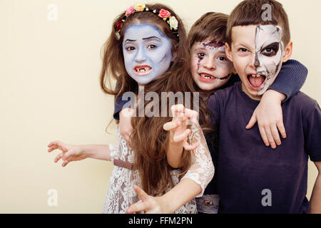 zombie apocalypse kids concept. Birthday party celebration facepaint on children dead bride, scar face, zombi skeleton together Stock Photo