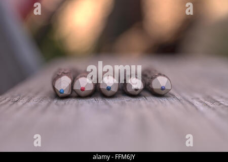 Macro view of bark covered colored pencil tips on a wood bench background Stock Photo