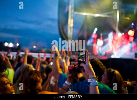 A crowd of people at a concert with hands and phone cameras in the air,  Myrtle Beach, South Carolina Stock Photo