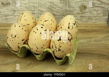 Six large white eggs with black spots in the mold. Easter decoration on the wooden background. Horizontal view. Stock Photo