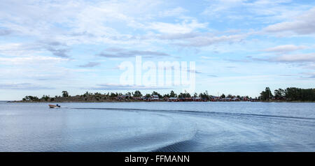 A turn around at sea. Calm sea and a village in the background. Red wooden buildings by the sea. Stock Photo