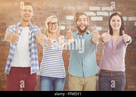 Composite image of portrait of smiling business people with thumbs up Stock Photo