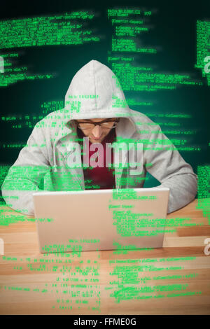Composite image of man with hooded shirt working on laptop Stock Photo