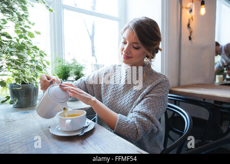 Happy woman drinking tea in cafe Stock Photo