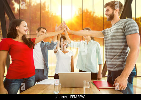 Composite image of happy business team putting their hands together Stock Photo
