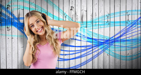 Composite image of portrait of a beautiful woman dancing with headphones
