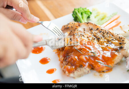 woman eating steak in a restaurant Stock Photo