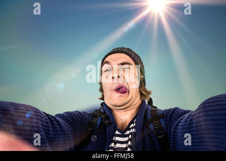Composite image of hipster holding camera and grimacing Stock Photo