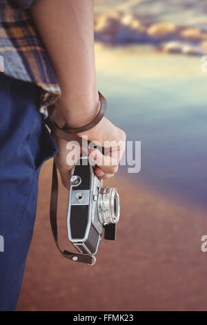 Composite image of cropped image of man holding camera Stock Photo